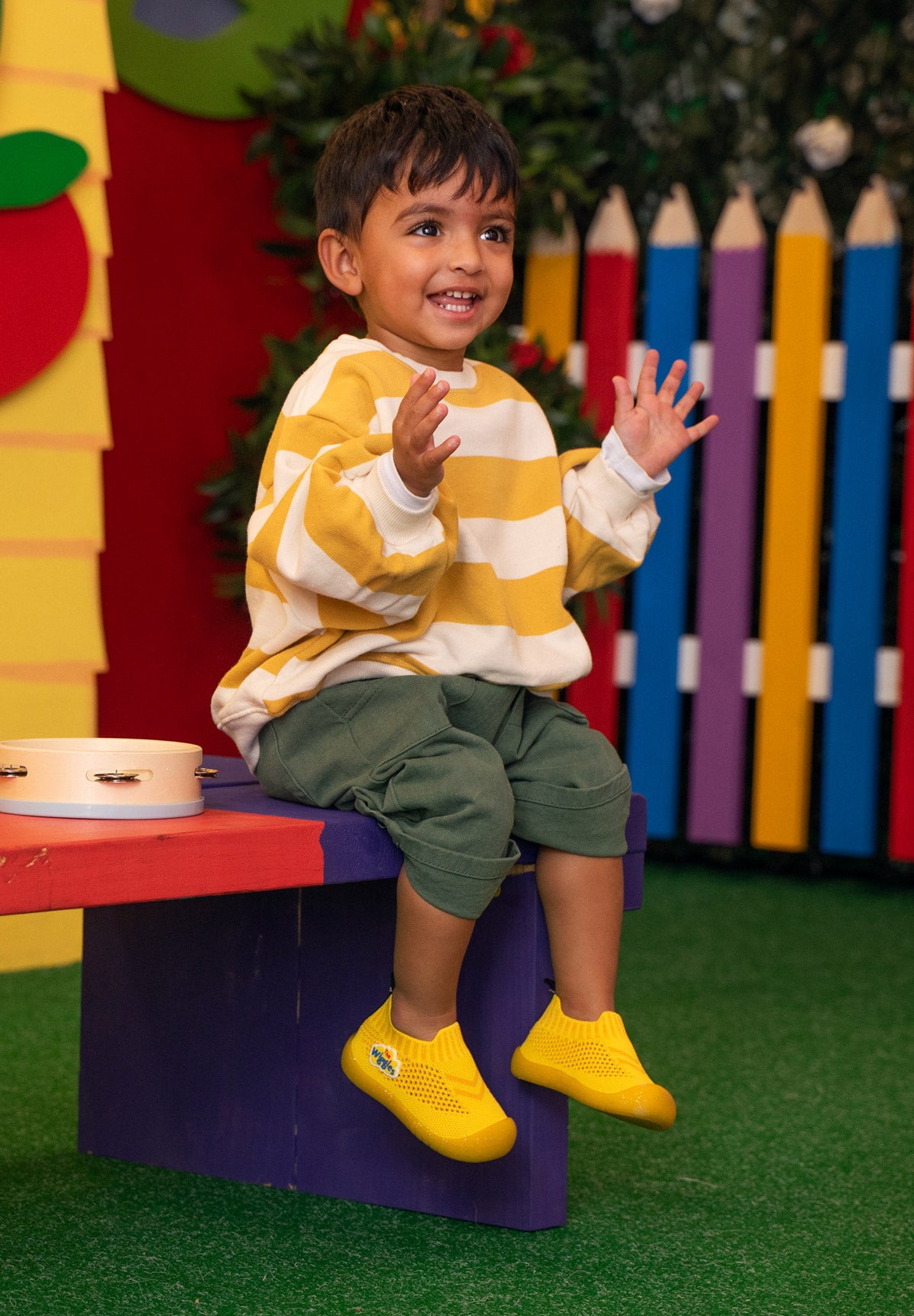 Child sitting on a colorful step stool
