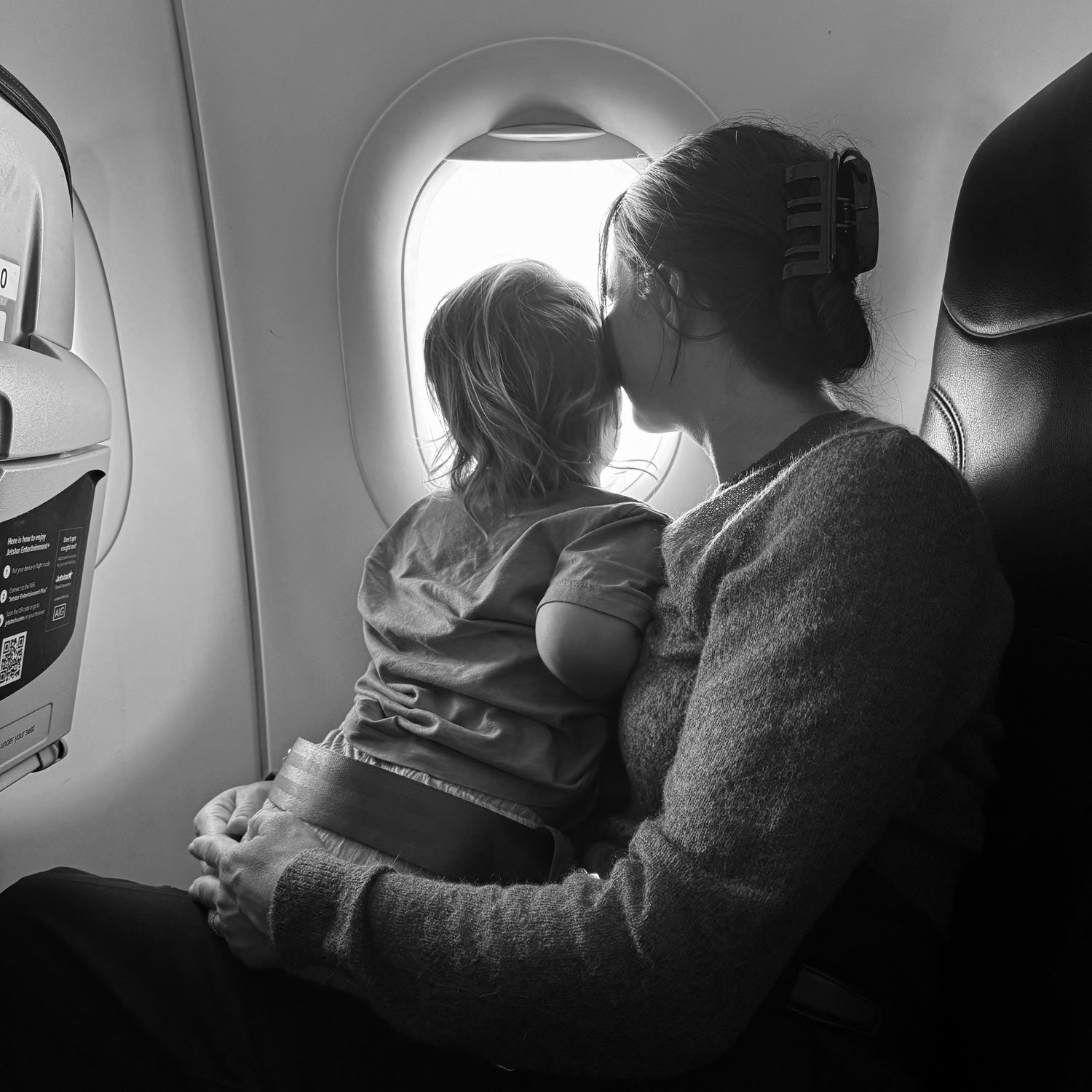Parent and child looking out an airplane window.