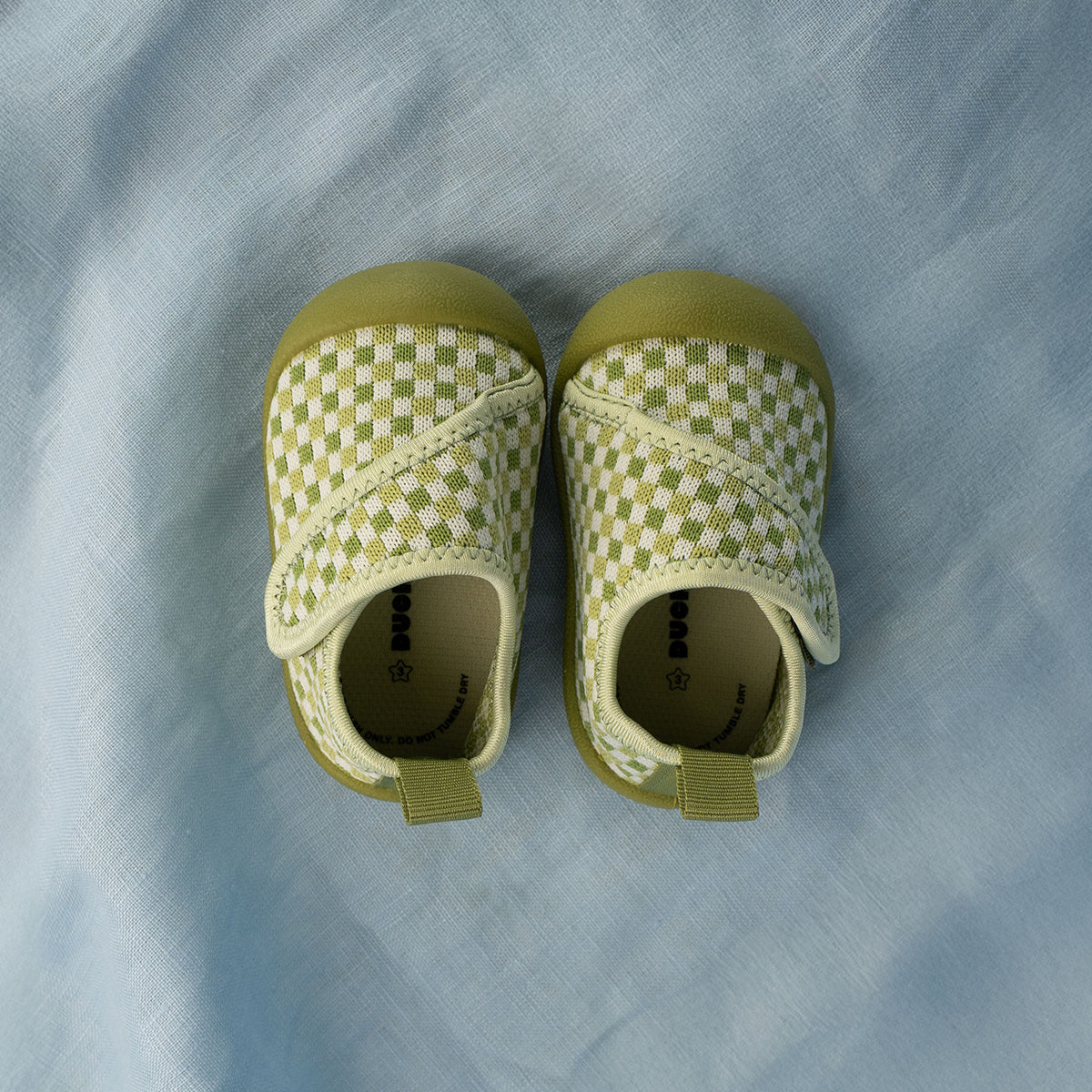 Pair of green checkered baby shoes