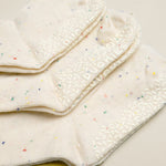Stack of white cloths with colorful specks